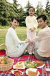 Girl and parents having picnic in the park