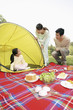 Girl sitting in the tent, man and woman looking at her