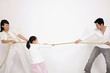 Girl playing tug-of-war with her parents