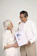 Senior man receiving gift from senior woman