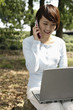 Woman talking on the phone while using laptop