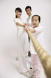 Girl pulling rope with the help of her parents