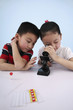 Girl looking through microscope with boy beside her