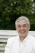 Senior man smiling while sitting on swing