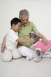 Senior man and boy playing with dog