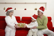 Foto: Boy giving senior woman present, senior man watching Boy giving senior woman present, senior man watching