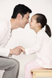Photo: Man and girl holding hands while rubbing nose Man and girl holding hands while rubbing nose