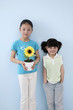 Photo: Girl holding sunflower plant with another girl beside her Girl holding sunflower plant with another girl beside her