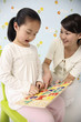 Photo: Woman showing girl alphabet puzzle Woman showing girl alphabet puzzle