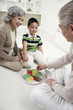 Senior couple playing Chinese checkers with boy