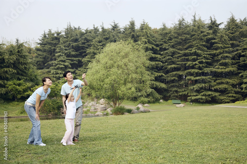 Foto: Girl flying kite with her parents Girl flying kite with her parents