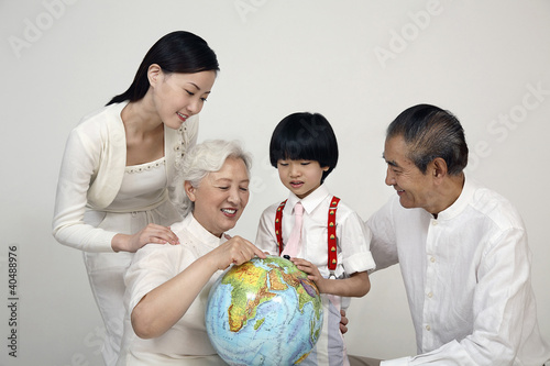 Photo: Boy and senior woman looking at globe, woman and senior man watching Boy and senior woman looking at globe, woman and senior man watching
