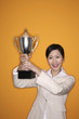Businesswoman lifting trophy