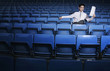 Businessman reading a newspaper in an empty stadium