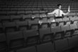 Businessman reading a newspaper in an empty stadium