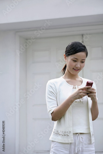 Photo: Woman text messaging on the cellphone Woman text messaging on the cellphone