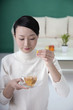 Foto: Woman dipping teabag into cup Woman dipping teabag into cup