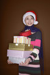 Foto: Woman looking up while holding a stack of presents Woman looking up while holding a stack of presents
