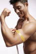 Man measuring his muscular arm