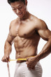 Photo: Man measuring his waist Man measuring his waist