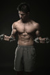Muscular man lifting dumbbells