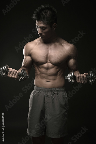 Photo: Muscular man lifting dumbbells Muscular man lifting dumbbells