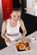 Photo: Woman enjoying a plate of lightly buttered waffle stacks with diced fresh strawberries and jam Woman enjoying a plate of lightly buttered waffle stacks with diced fresh strawberries and jam