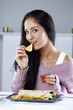 Foto: Woman enjoying tortilla wraps served with nachos and tomato dip on the side Woman enjoying tortilla wraps served with nachos and tomato dip on the side