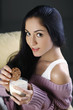 Foto: Woman holding cookie and a glass of milk Woman holding cookie and a glass of milk