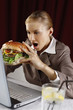 Photo: Businesswoman about to bite on a big burger Businesswoman about to bite on a big burger