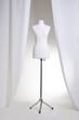 Clothing mannequin white on a light background near the curtains Clothing mannequin white on a light background near the curtains