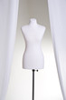 Clothing mannequin white on a light background near the curtains Clothing mannequin white on a light background near the curtains