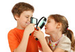 Brother and sister looking at each other through loupe