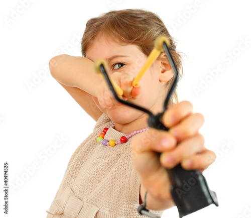 Photo: Girl with slingshot aim to camera isolated on white background Girl with slingshot aim to camera isolated on white background