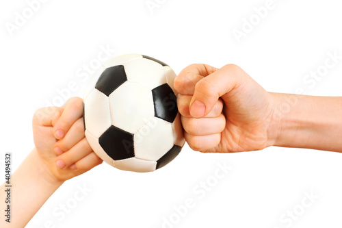 Photo: Children fists rested in little soccer ball isolated on white Children fists rested in little soccer ball isolated on white