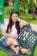asian woman sitting and smile on bench