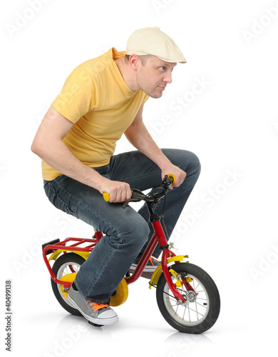 Photo: Cool guy goes on a children's bicycle on white Cool guy goes on a children's bicycle on white