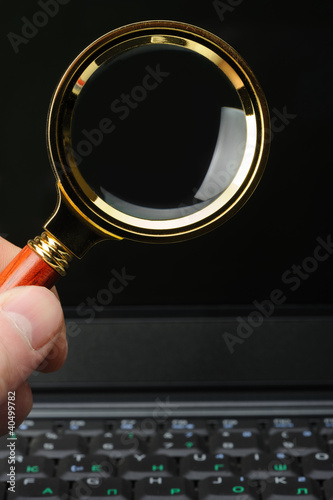 Photo: Magnifying glass in his hand and a notebook Magnifying glass in his hand and a notebook