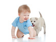 Photo: cute child playing and crawling away a puppy, puppy following cute child playing and crawling away a puppy, puppy following