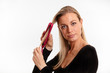 Beautiful blonde woman straightening her hair