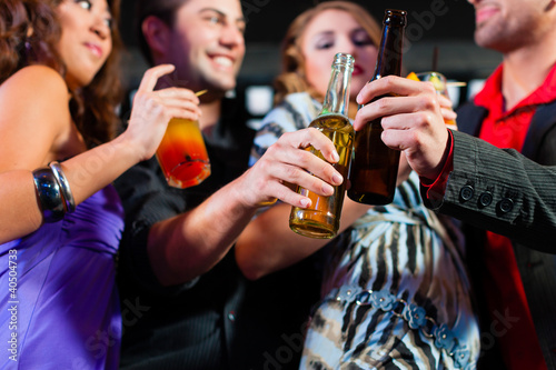 Photo: People with cocktails in bar or club People with cocktails in bar or club