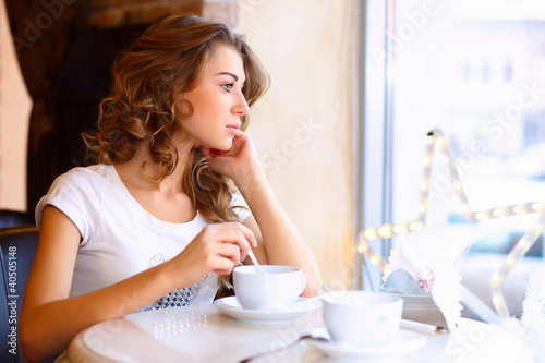 Photo: Young pretty woman sitting in restaurant Young pretty woman sitting in restaurant