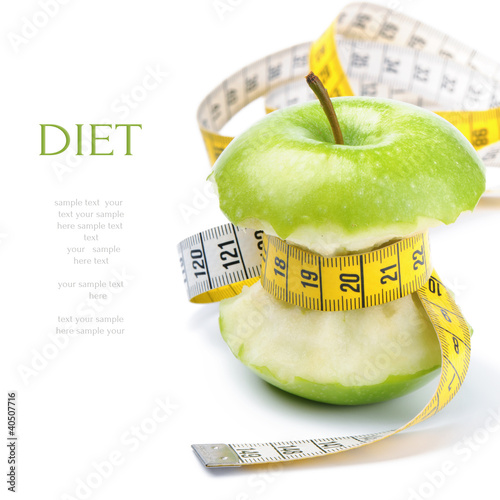 Photo: Green apple core and measuring tape. Diet concept Green apple core and measuring tape. Diet concept