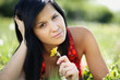 Photo: Beautiful woman lying in the garden holding a dandelion Beautiful woman lying in the garden holding a dandelion
