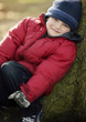 Portrait of a boy leaning on a tree