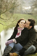 Happy couple sitting by the lake