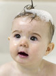 Baby girl with soap suds on her hair