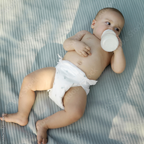 Photo: Baby boy drinking milk from baby bottle Baby boy drinking milk from baby bottle
