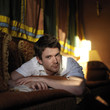Man lying on the couch reading book