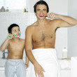 Father and son brushing teeth together